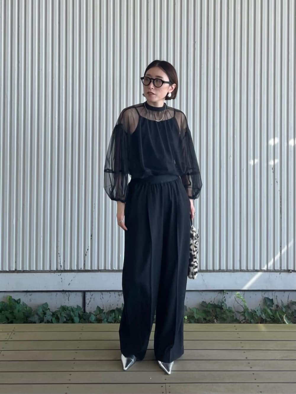 ブラック系のシャツ/ブラウス、ブラック系のその他パンツ、ブラウン系のハンドバッグを着用したレディースの秋コーディネートの2枚目の写真