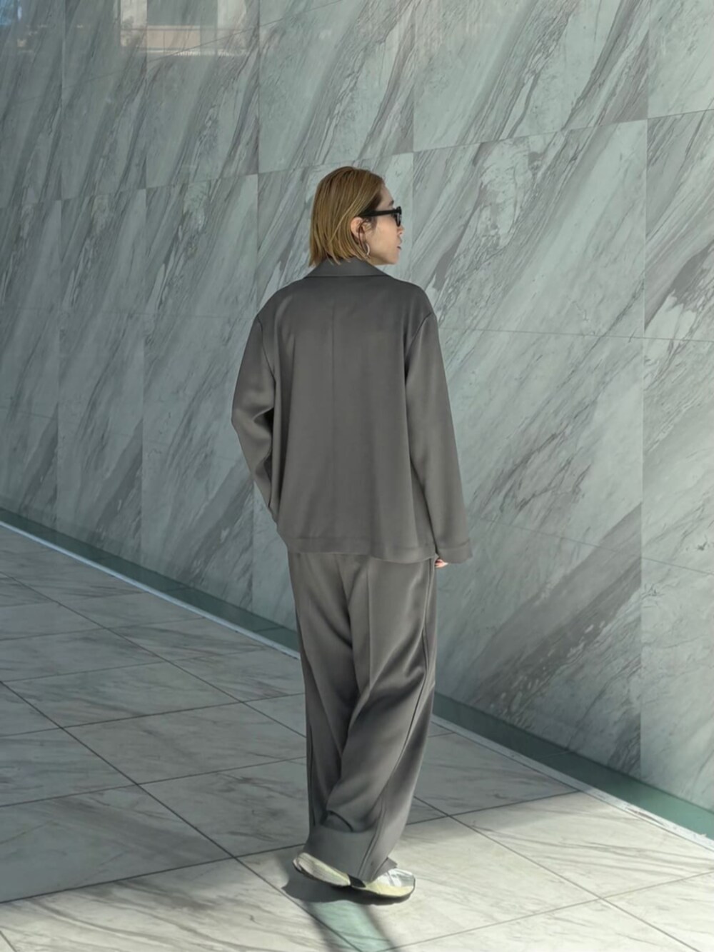 グレー系のその他パンツ、グレー系のテーラードジャケット、ブラック系のTシャツ/カットソーを着用したレディースの春コーディネートの3枚目の写真