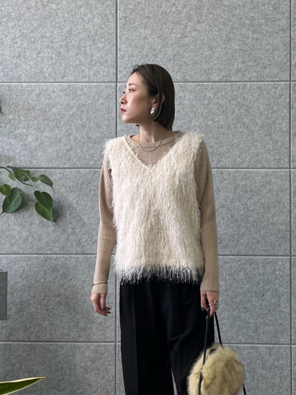 ホワイト系のベスト、ベージュ系のニット/セーター、ブラック系のその他パンツを着用したレディースの冬コーディネートの3枚目の写真