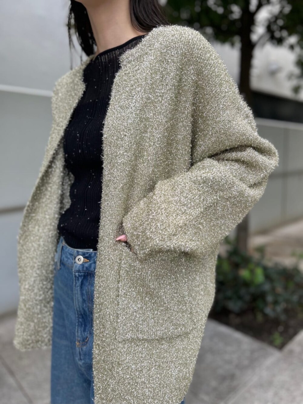 ブラック系のニット/セーター、ブルー系のデニムパンツ、ゴールド系のカーディガン/ボレロを着用したレディースの秋コーディネートの3枚目の写真