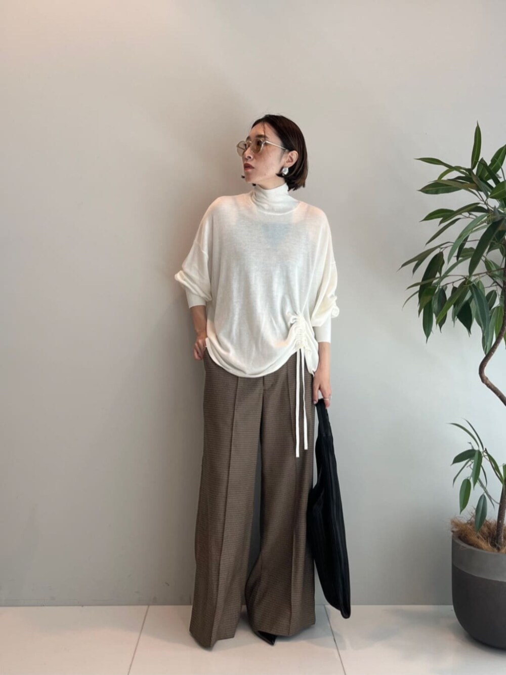 ホワイト系のニット/セーター、ベージュ系のその他パンツ、ブラック系のトートバッグを着用したレディースの秋コーディネートの2枚目の写真