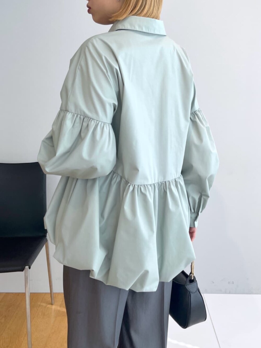 グレー系のその他パンツ、グリーン系のシャツ/ブラウス、ブラック系のハンドバッグを着用したレディースの春コーディネートの4枚目の写真