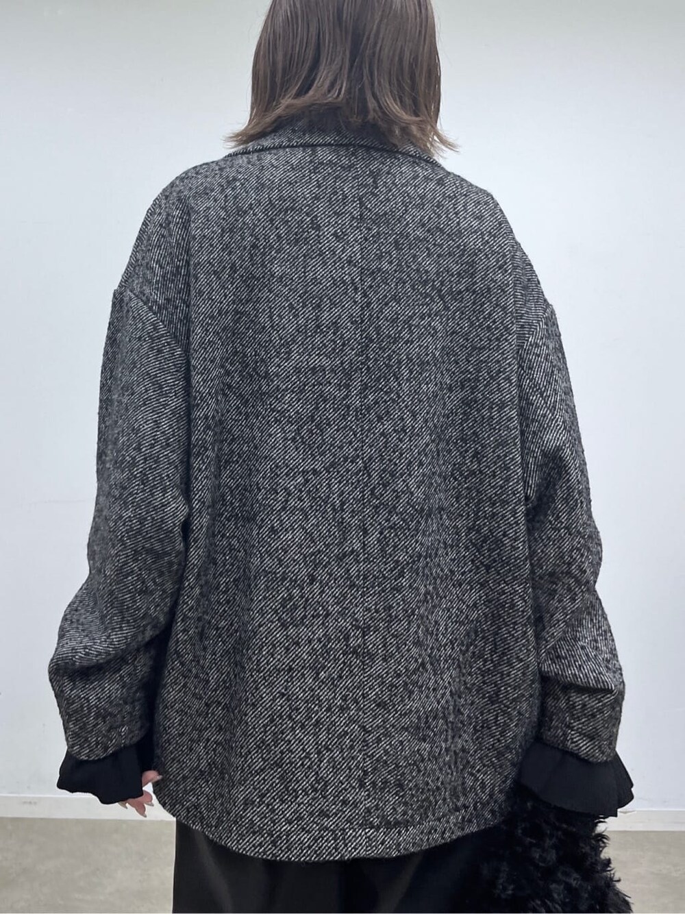 ブラック系のチェスターコート、ブラック系のニット/セーター、ブラック系のその他パンツを着用したレディースの秋コーディネートの8枚目の写真