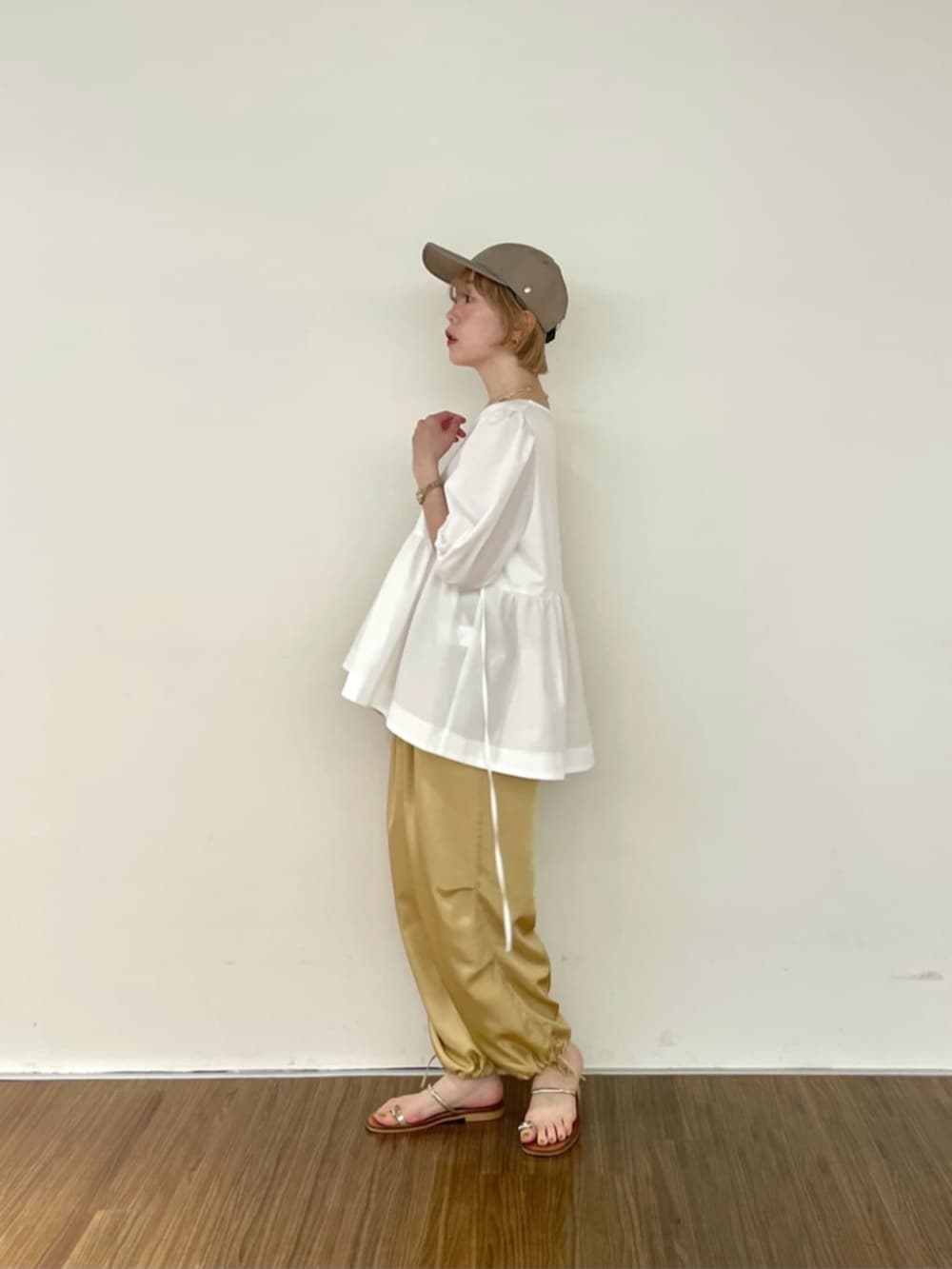 ベージュ系のその他パンツ、ホワイト系のTシャツ/カットソー、グリーン系のキャップを着用したレディースの夏コーディネートの2枚目の写真