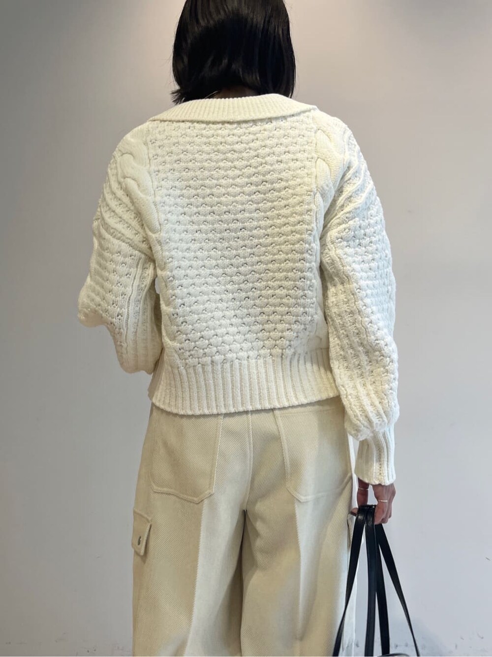 ホワイト系のニット/セーター、ホワイト系のその他パンツ、ブラック系のハンドバッグを着用したレディースの秋コーディネートの7枚目の写真