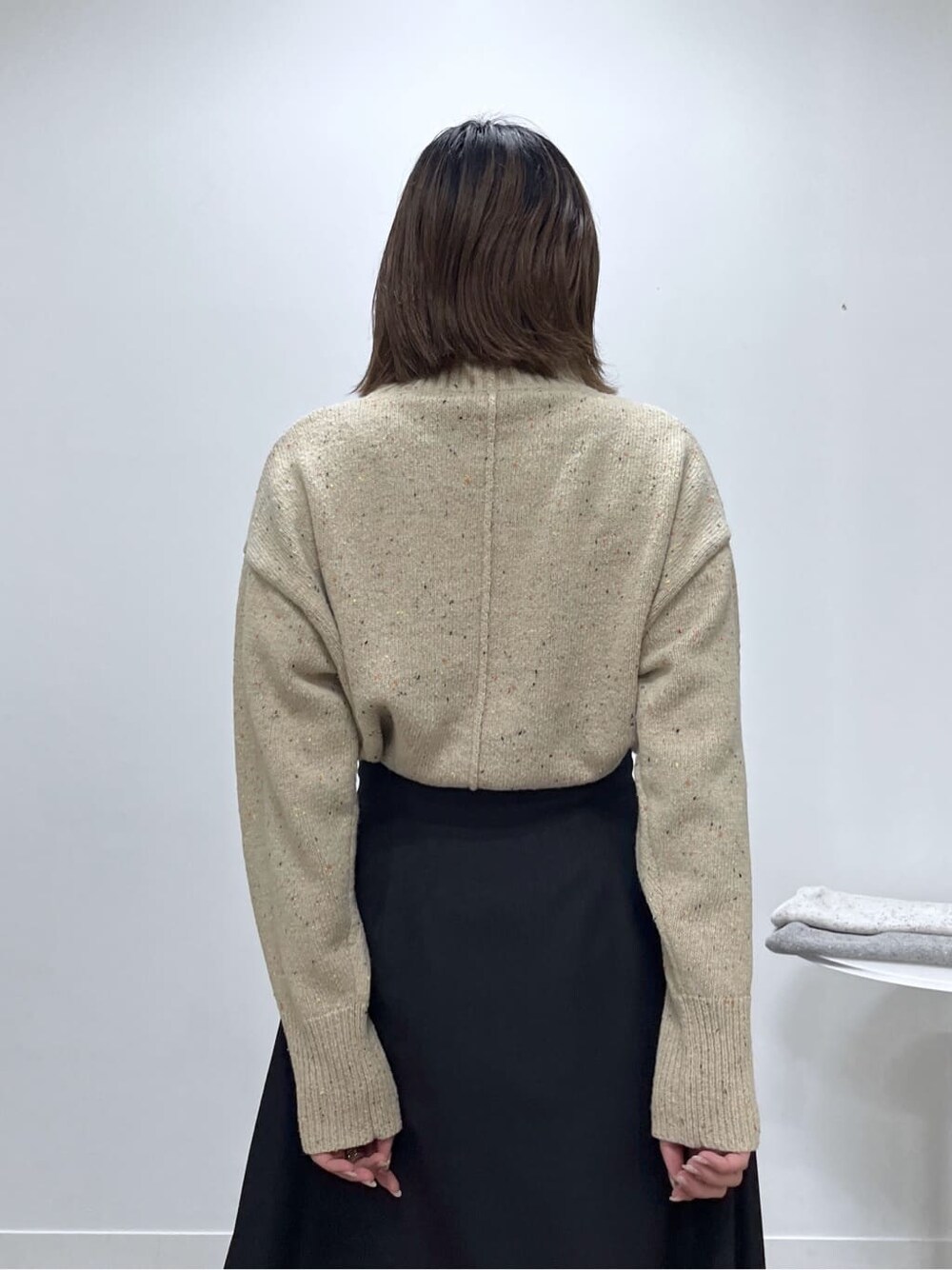 ベージュ系のニット/セーター、ブラック系のスカートを着用したレディースの冬コーディネートの9枚目の写真