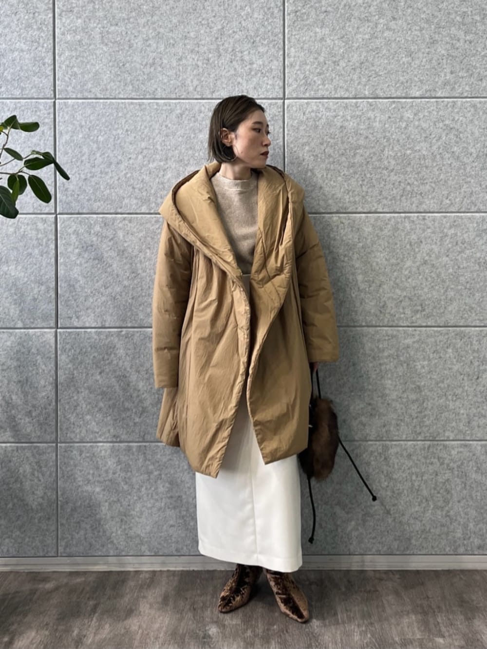 ブラウン系のブーツ、ホワイト系のスカート、ベージュ系のニット/セーターを着用したレディースの冬コーディネートの2枚目の写真