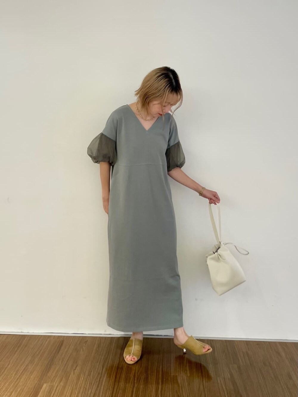 グリーン系のワンピース、ゴールド系のネックレスを着用したレディースの秋コーディネートの2枚目の写真