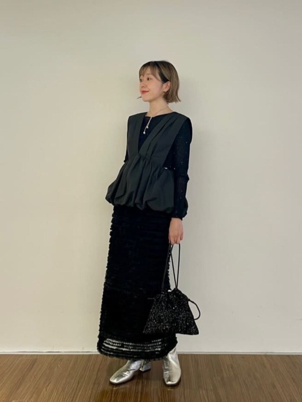 ブラック系のショルダーバッグ、ブラック系のシャツ/ブラウス、ブラック系のスカートを着用したレディースの秋コーディネートの3枚目の写真