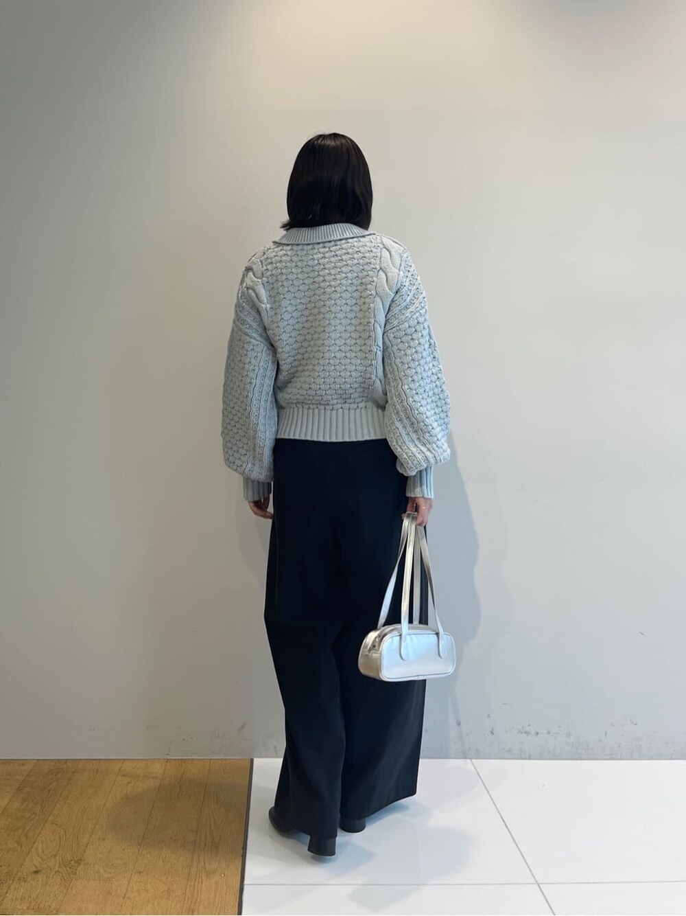 ブルー系のニット/セーター、ブラック系のその他パンツ、シルバー系のハンドバッグを着用したレディースの秋コーディネートの4枚目の写真