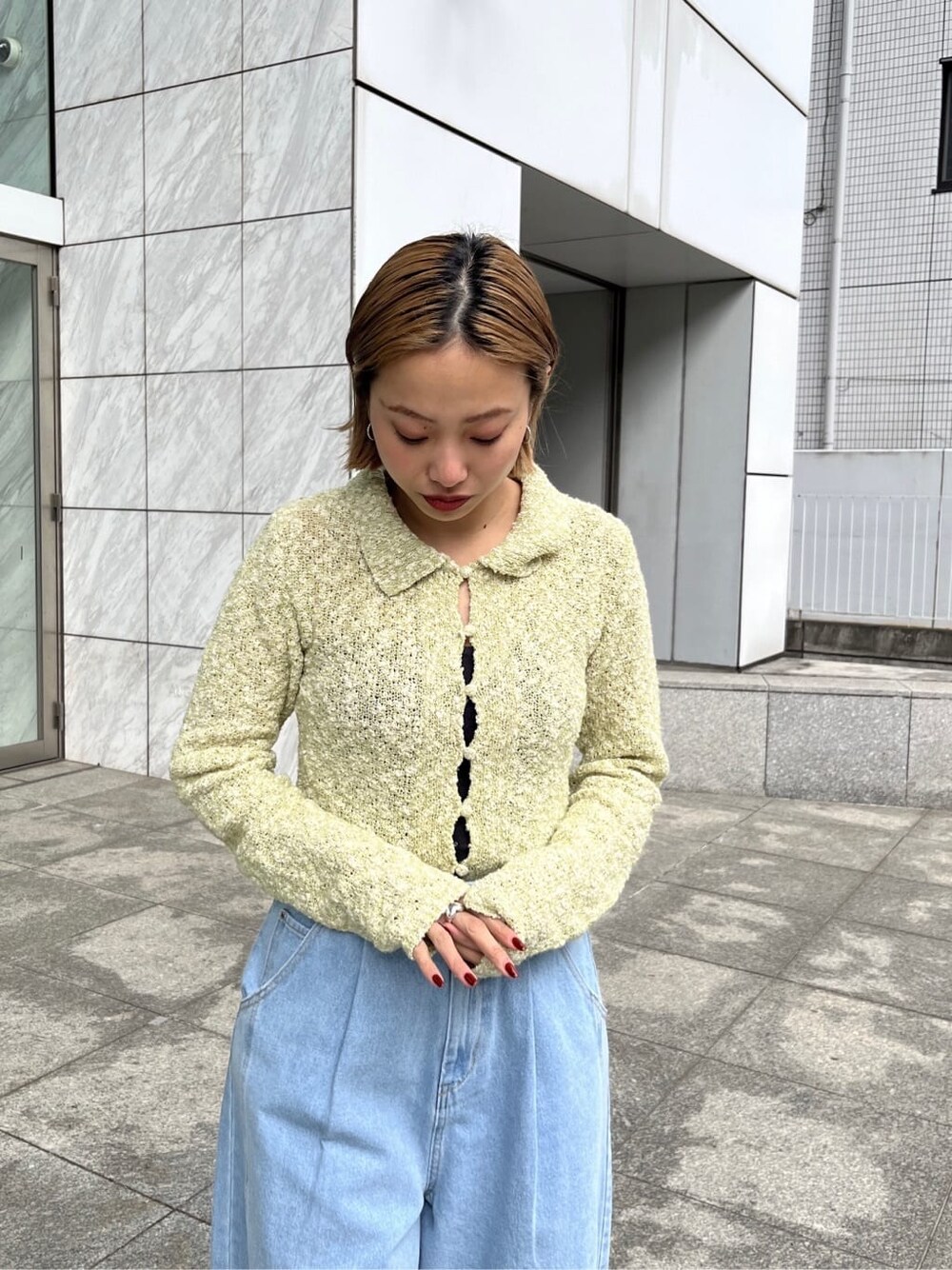 ブラウン系のトレンチコート、ブルー系のデニムジャケット、グリーン系のニット/セーターを着用したレディースの春コーディネートの9枚目の写真
