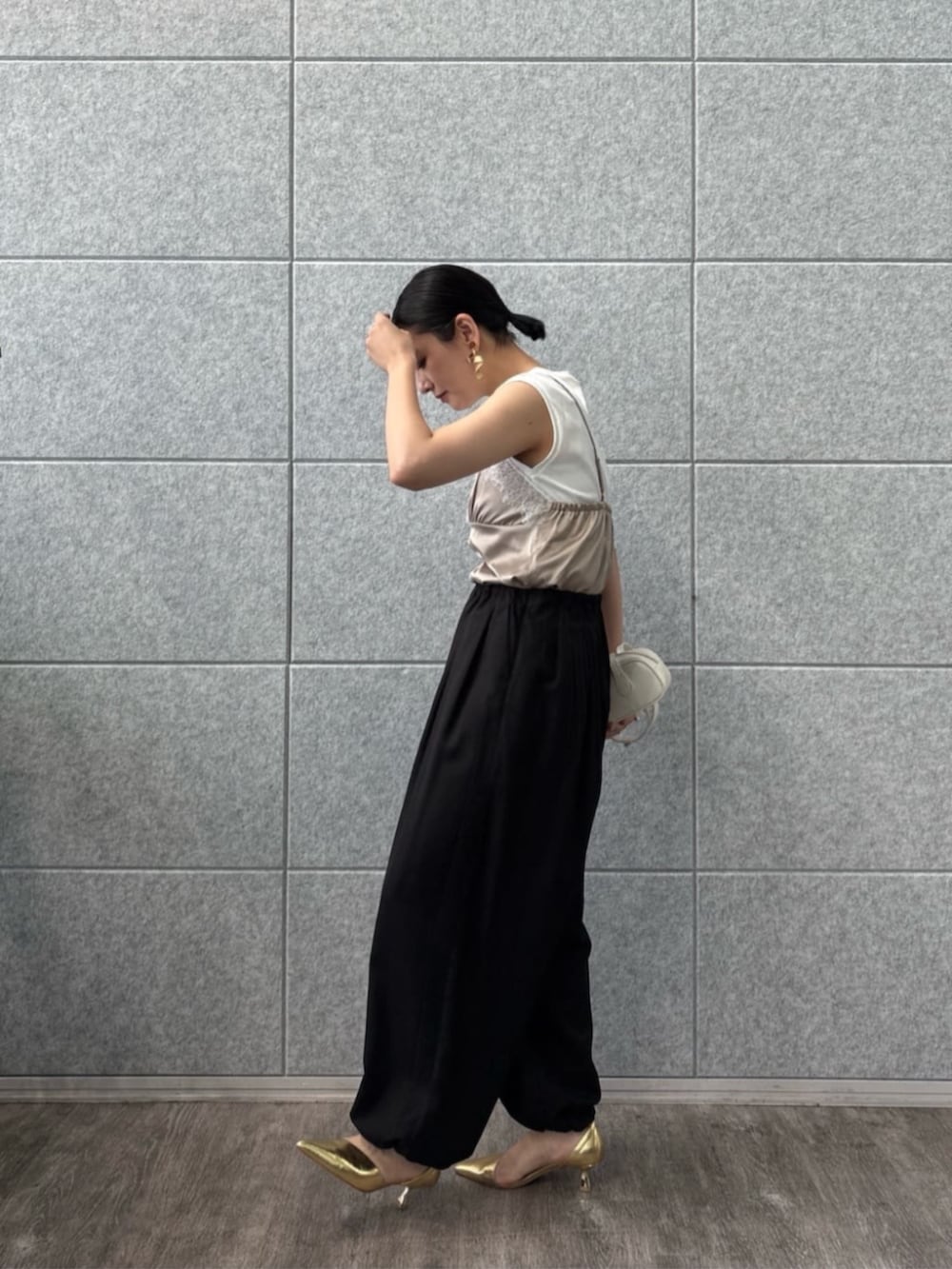 ブラック系のその他パンツ、ベージュ系のTシャツ/カットソーを着用したレディースの夏コーディネートの2枚目の写真