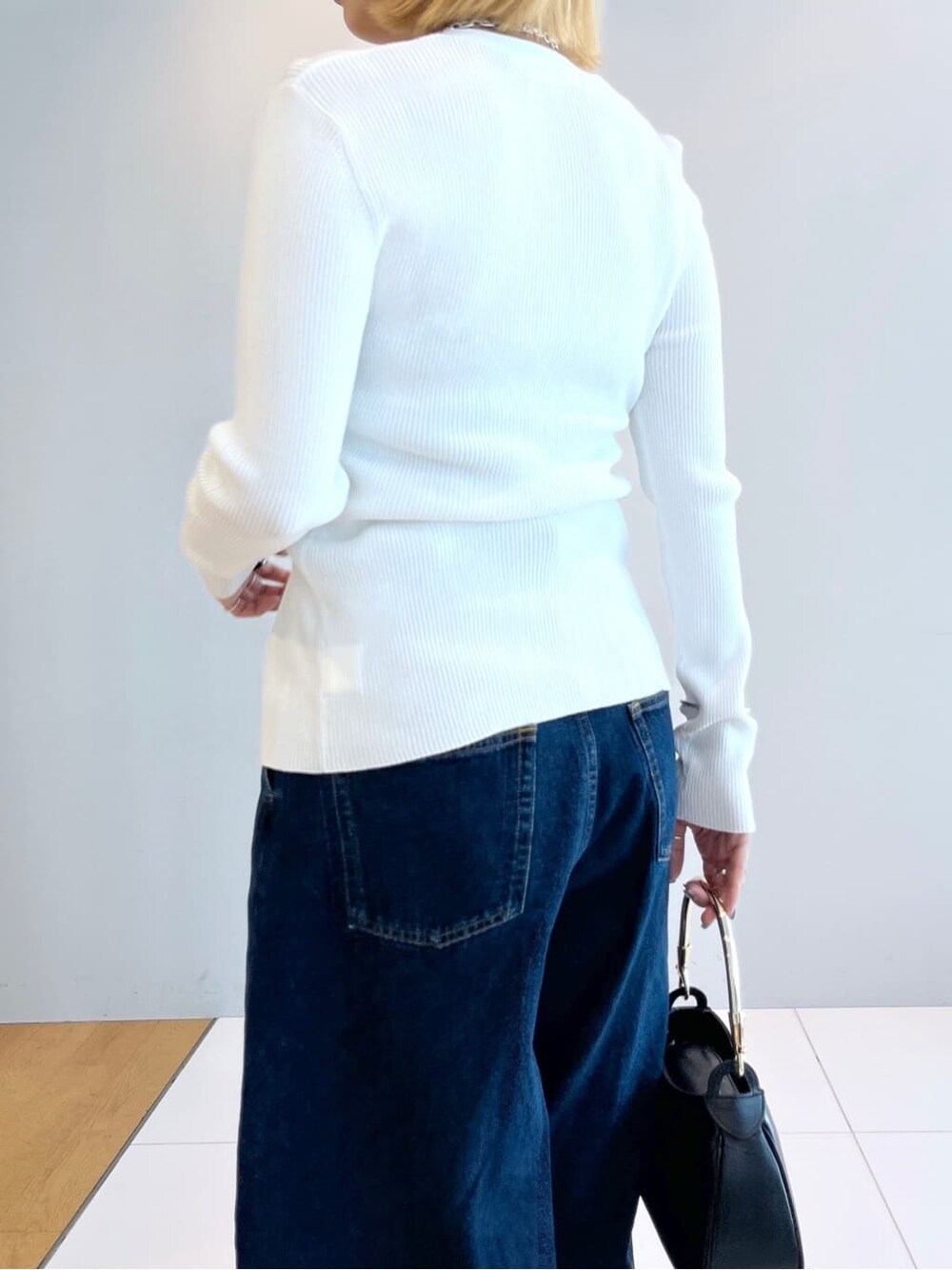 ホワイト系のカーディガン/ボレロ、ブルー系のデニムパンツを着用したレディースの春コーディネートの5枚目の写真