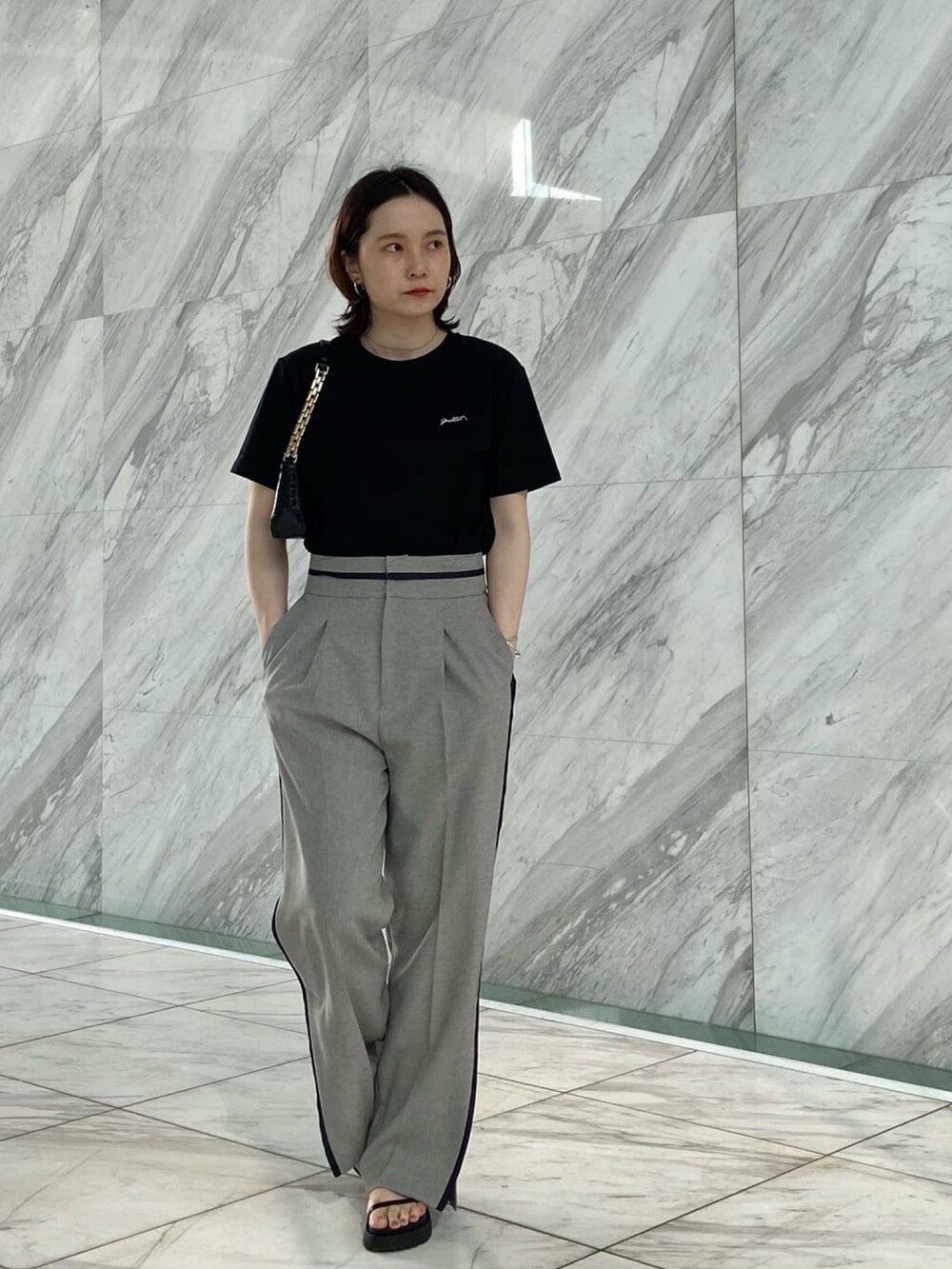 グレー系のその他パンツ、ブラック系のサンダル、ブラック系のTシャツ/カットソーを着用したレディースの夏コーディネートの2枚目の写真