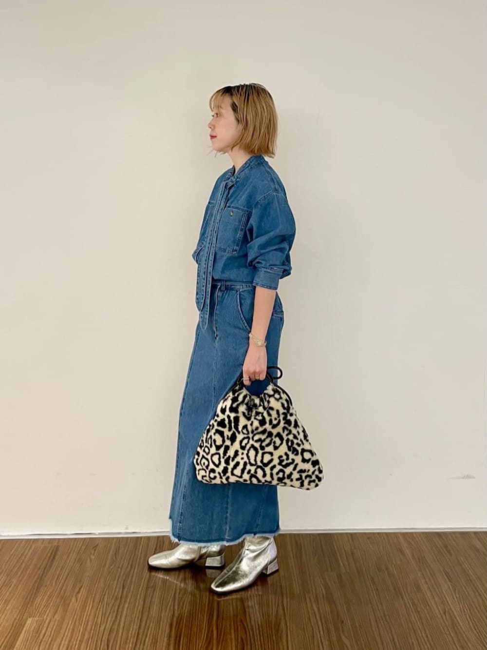 ブルー系のシャツ/ブラウス、ブルー系のデニムスカート、ブラウン系のハンドバッグを着用したレディースの秋コーディネートの2枚目の写真