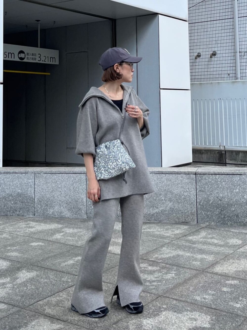 シルバー系のショルダーバッグ、グレー系のニット/セーター、グレー系のその他パンツを着用したレディースの秋コーディネートの2枚目の写真