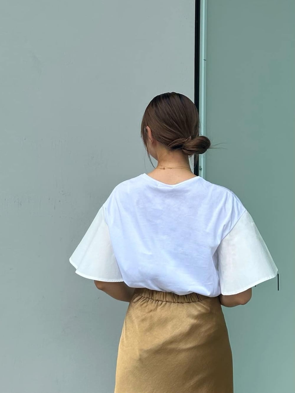 イエロー系のスカート、ホワイト系のサンダル、ホワイト系のTシャツ/カットソーを着用したレディースの夏コーディネートの3枚目の写真