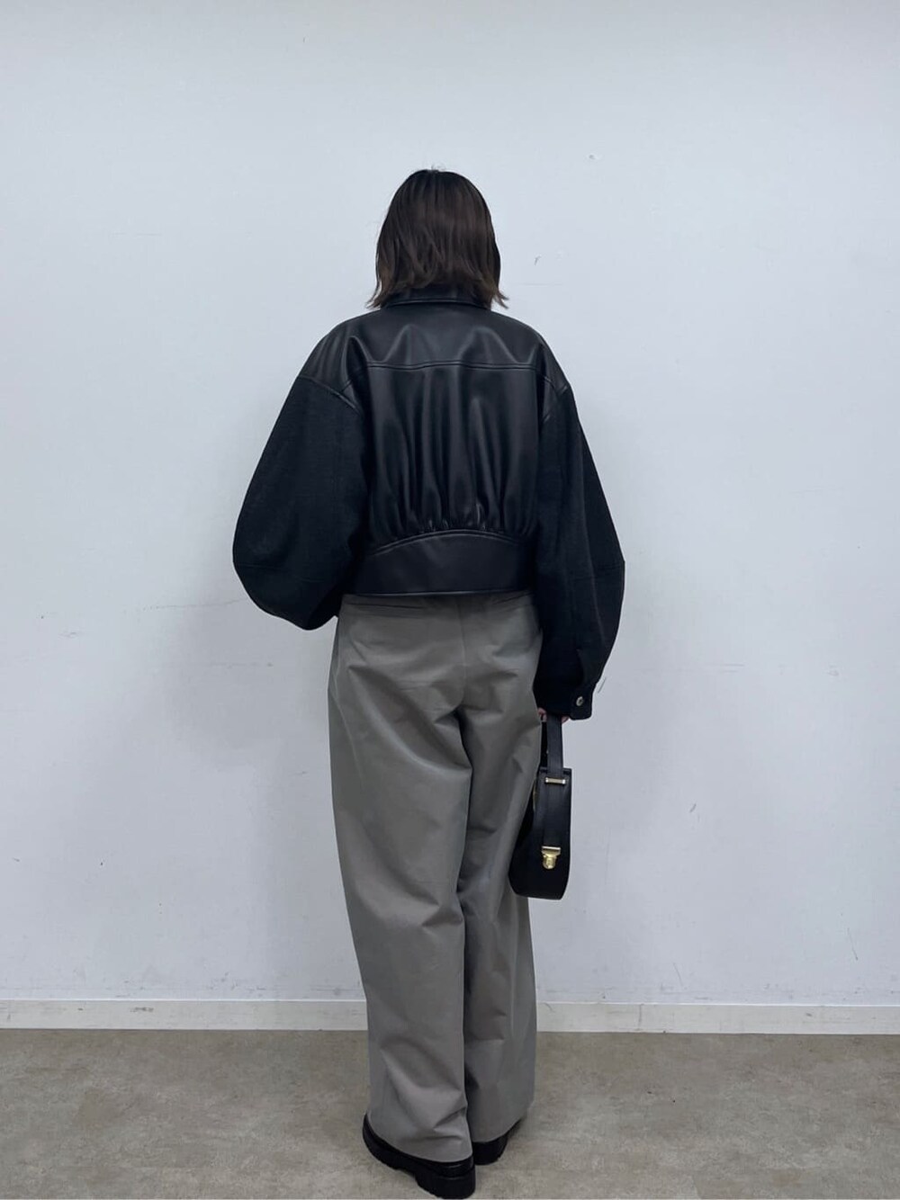 ブラック系のブルゾン、ベージュ系のニット/セーター、グレー系のその他パンツを着用したレディースの冬コーディネートの4枚目の写真
