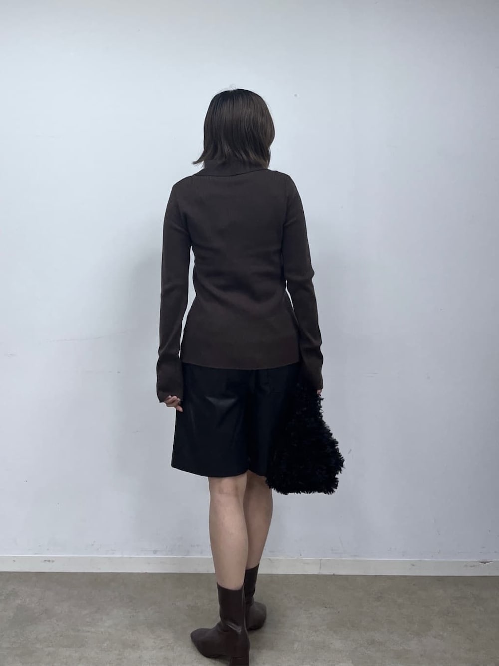 ブラウン系のニット/セーター、ブラック系のその他パンツ、ブラック系のブーツを着用したレディースの秋コーディネートの5枚目の写真