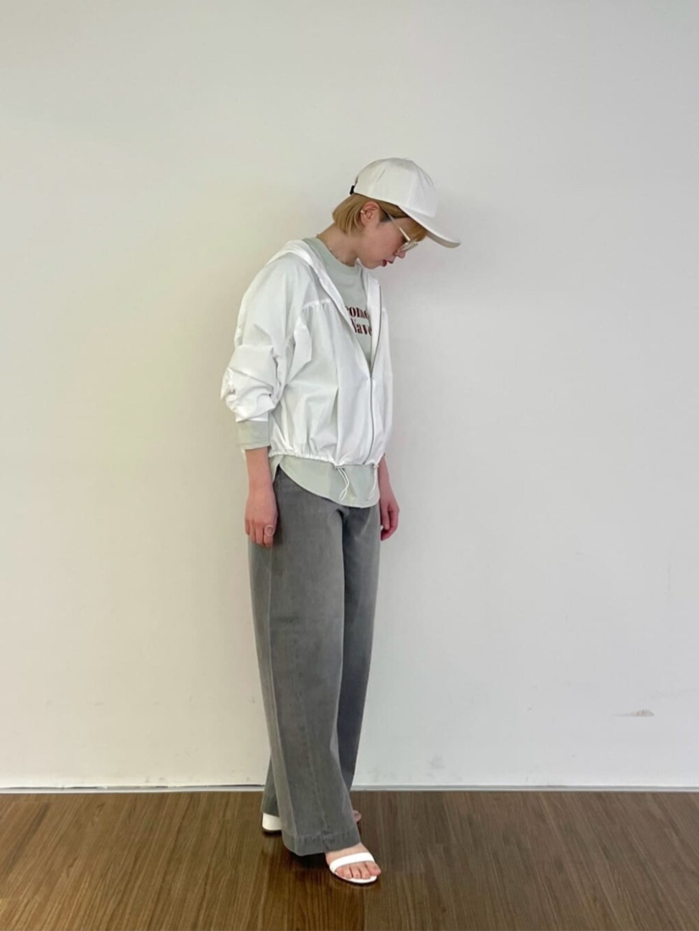 グレー系のデニムパンツ、グリーン系のTシャツ/カットソー、ホワイト系のブルゾンを着用したレディースの春コーディネートの2枚目の写真