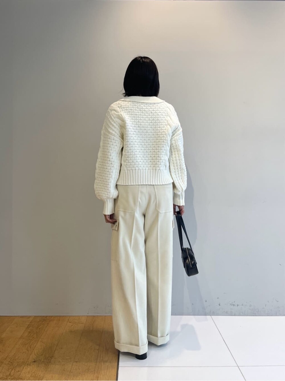 ホワイト系のニット/セーター、ホワイト系のその他パンツ、ブラック系のハンドバッグを着用したレディースの秋コーディネートの4枚目の写真