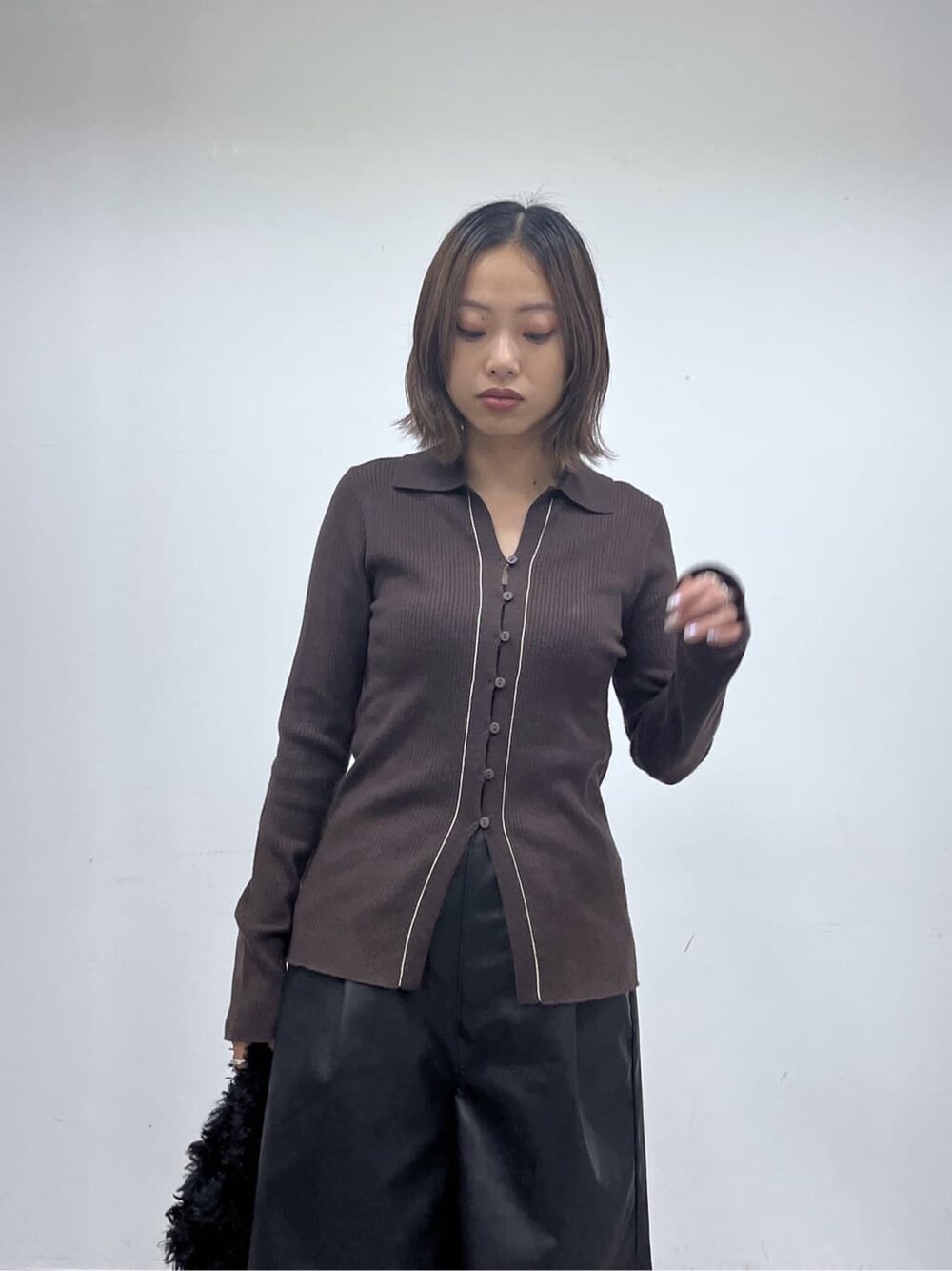 ブラウン系のニット/セーター、ブラック系のその他パンツ、ブラック系のブーツを着用したレディースの秋コーディネートの7枚目の写真