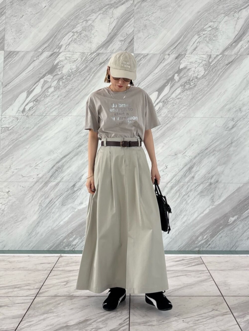 ホワイト系のTシャツ/カットソー、グリーン系のスカートを着用したレディースの春コーディネートの3枚目の写真