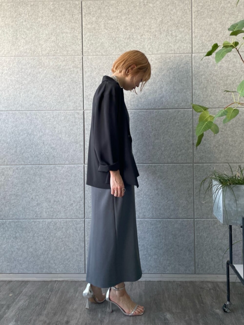 グレー系のワンピース、ブラック系のテーラードジャケットを着用したレディースの春コーディネートの2枚目の写真