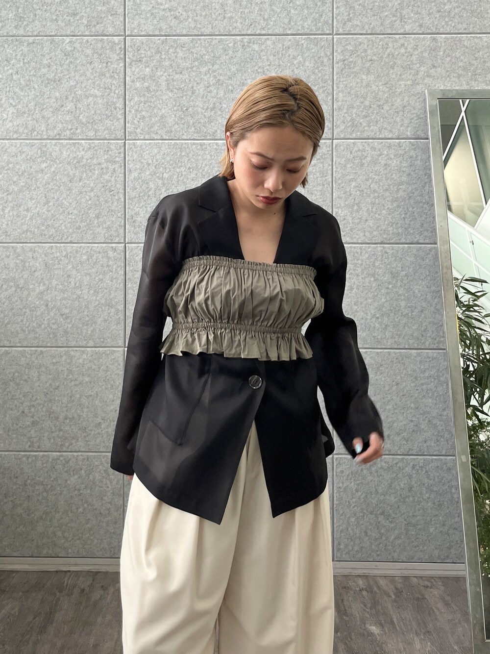 グリーン系のシャツ/ブラウス、ブラック系のテーラードジャケット、ホワイト系のその他パンツを着用したレディースの春コーディネートの7枚目の写真