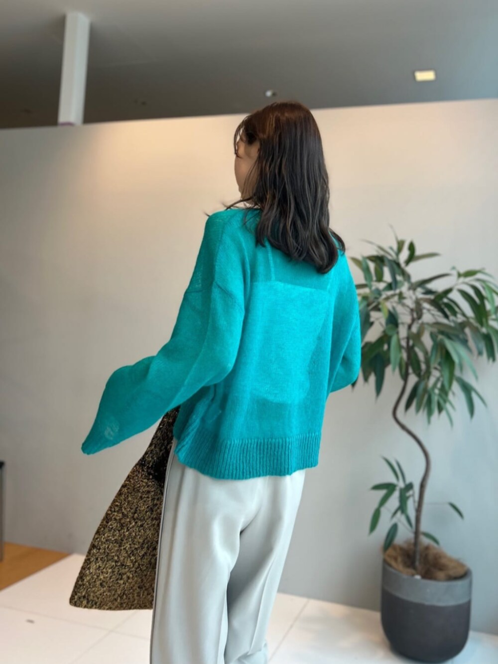 ゴールド系のトートバッグ、ブルー系のニット/セーター、ベージュ系のその他パンツを着用したレディースの秋コーディネートの2枚目の写真