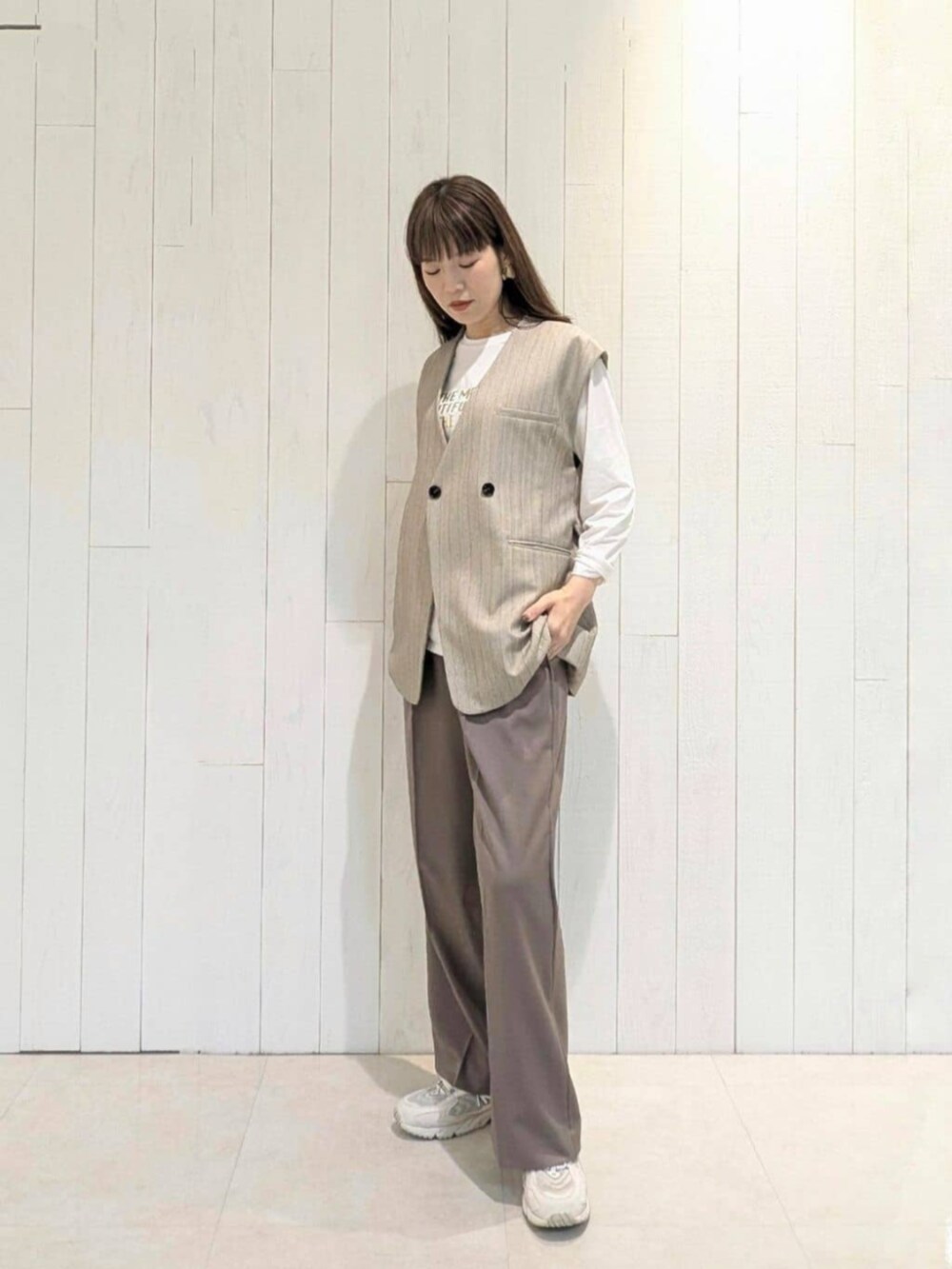 ブラウン系のその他パンツ、ベージュ系のベスト、ホワイト系のTシャツ/カットソーを着用したレディースの秋コーディネートの3枚目の写真