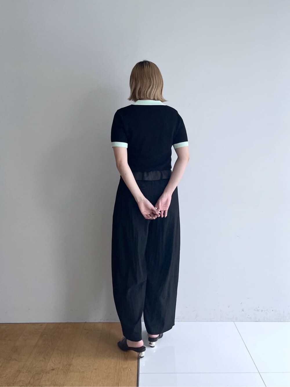 ブラック系のニット/セーター、ブラック系のその他パンツ、ブラック系のサンダルを着用したレディースの春コーディネートの4枚目の写真