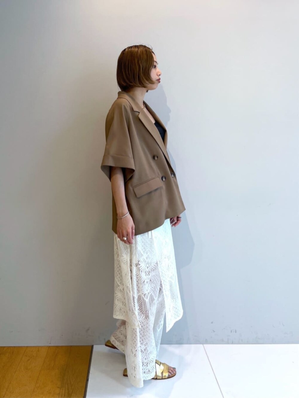 イエロー系のテーラードジャケットを着用したレディースの春コーディネートの3枚目の写真