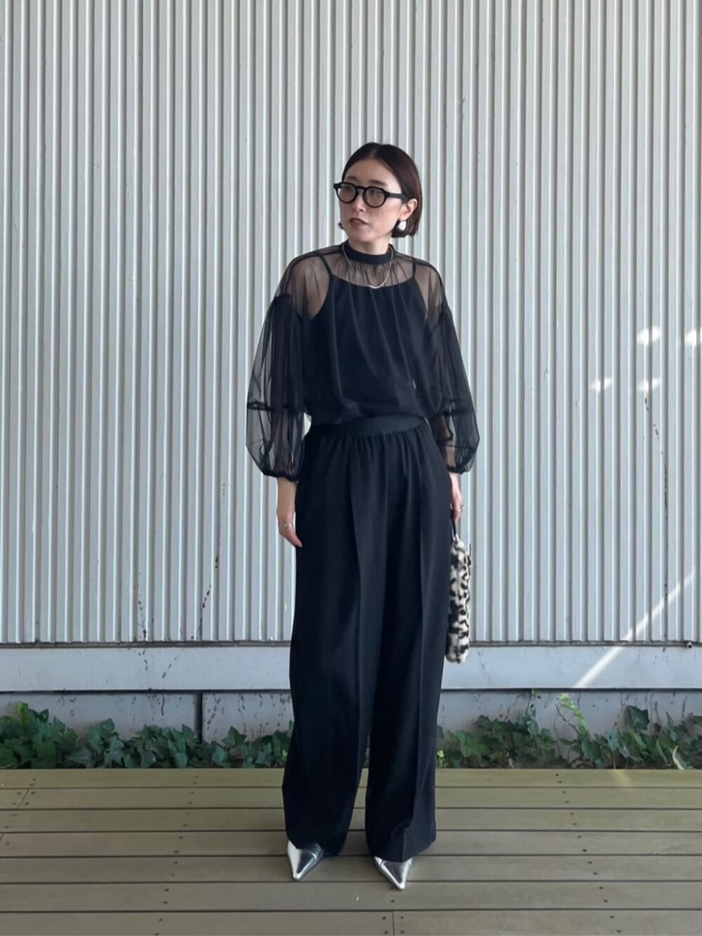 ブラック系のシャツ/ブラウス、ブラック系のその他パンツ、ブラウン系のハンドバッグを着用したレディースの秋コーディネートの2枚目の写真