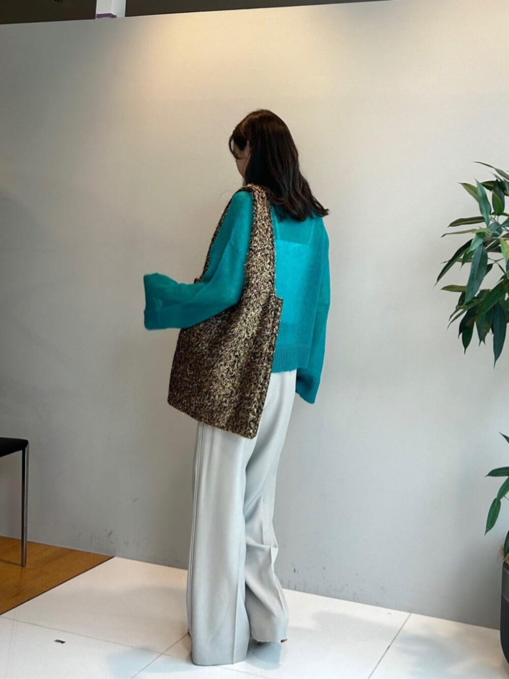 ゴールド系のトートバッグ、ブルー系のニット/セーター、ベージュ系のその他パンツを着用したレディースの秋コーディネートの3枚目の写真