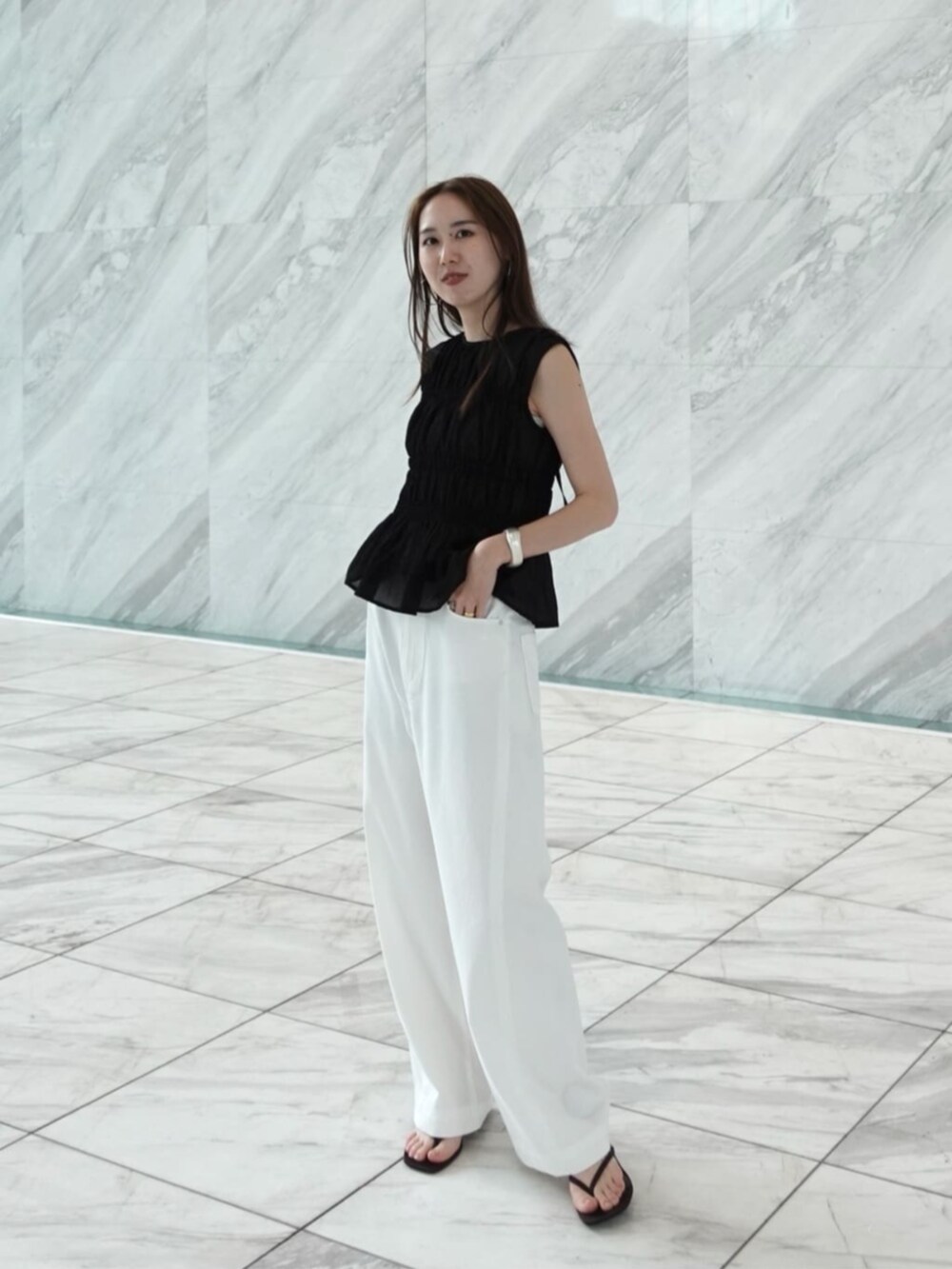 ホワイト系のデニムパンツ、ブラック系のシャツ/ブラウスを着用したレディースの春コーディネートの3枚目の写真