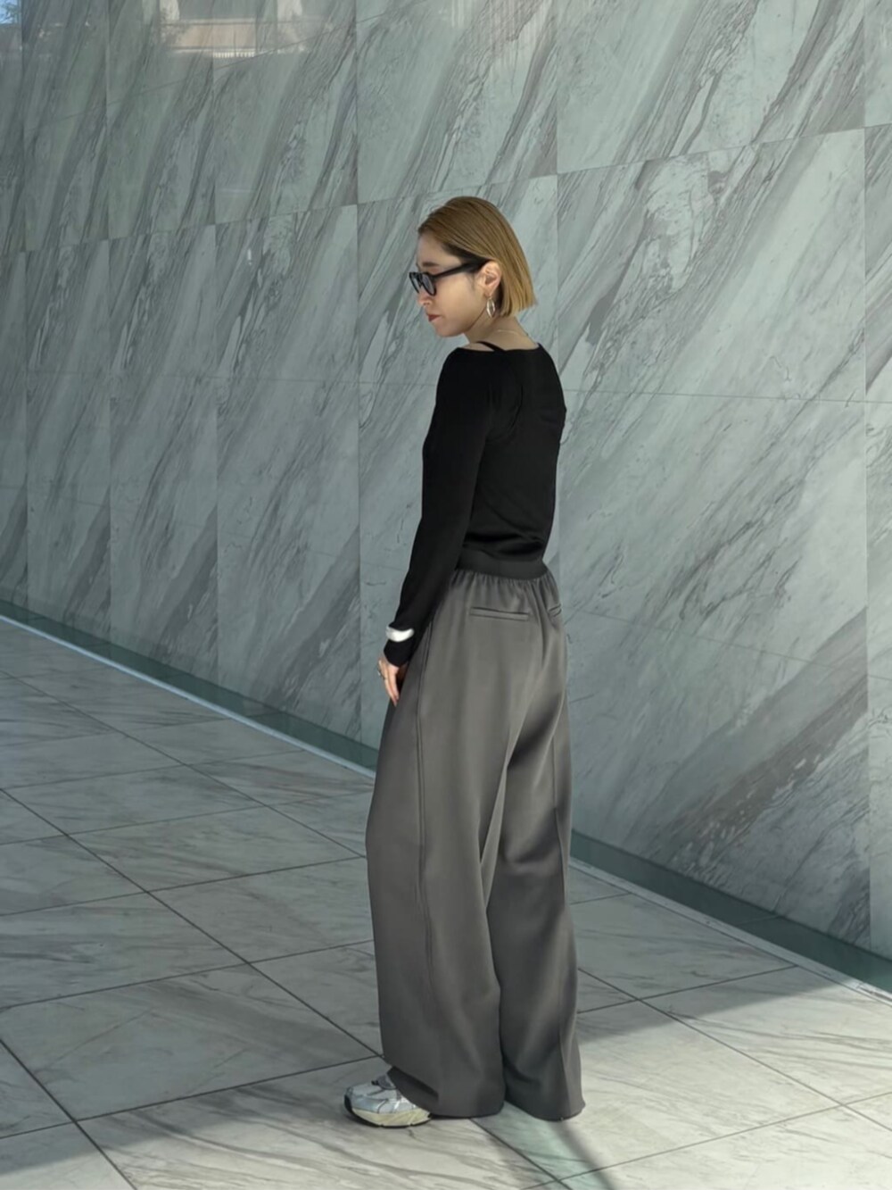 グレー系のその他パンツ、ブラック系のTシャツ/カットソーを着用したレディースの春コーディネートの3枚目の写真