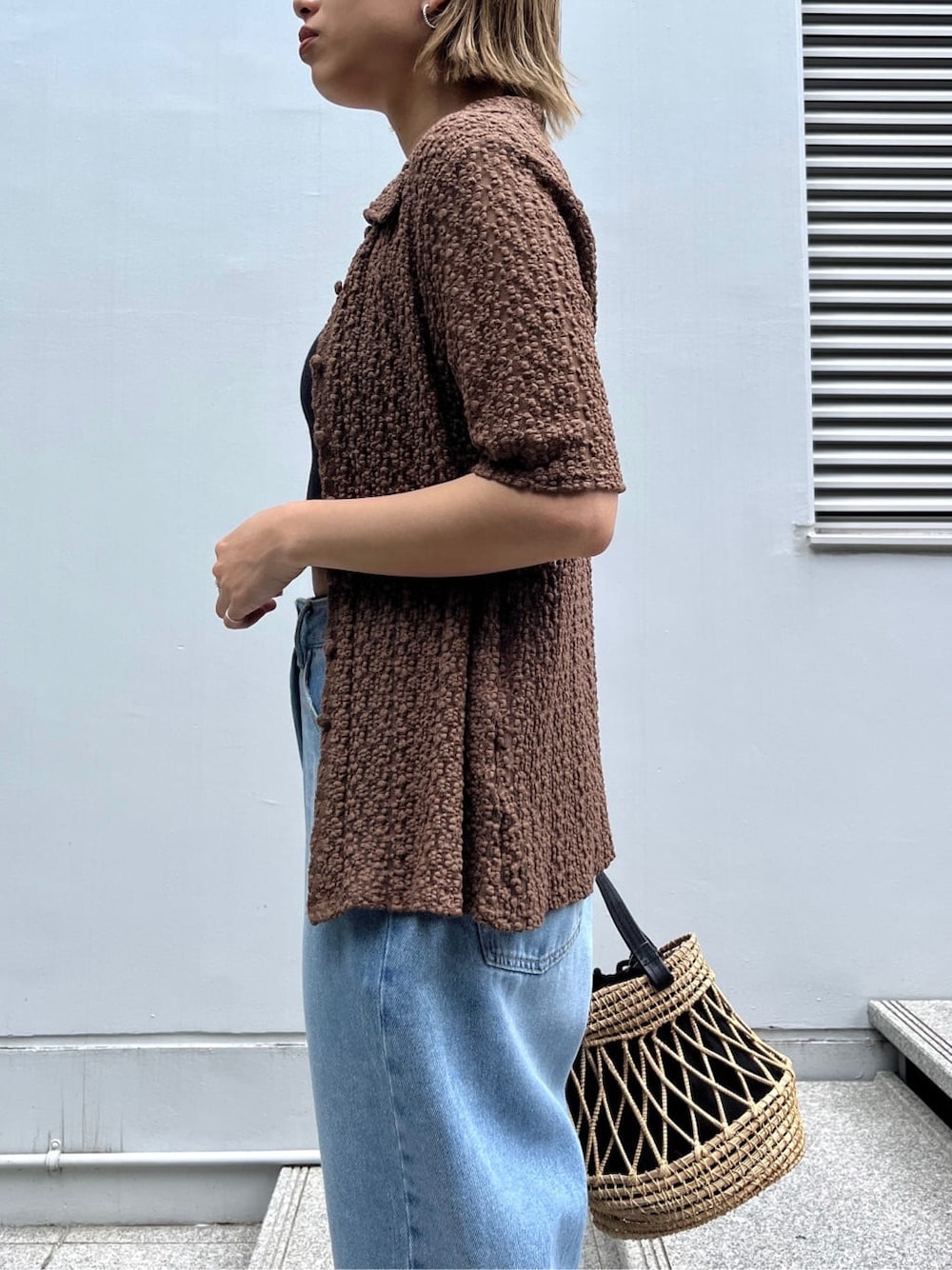 ブラウン系のシャツ/ブラウス、ブルー系のデニムパンツ、ブラック系のハンドバッグを着用したレディースの夏コーディネートの6枚目の写真