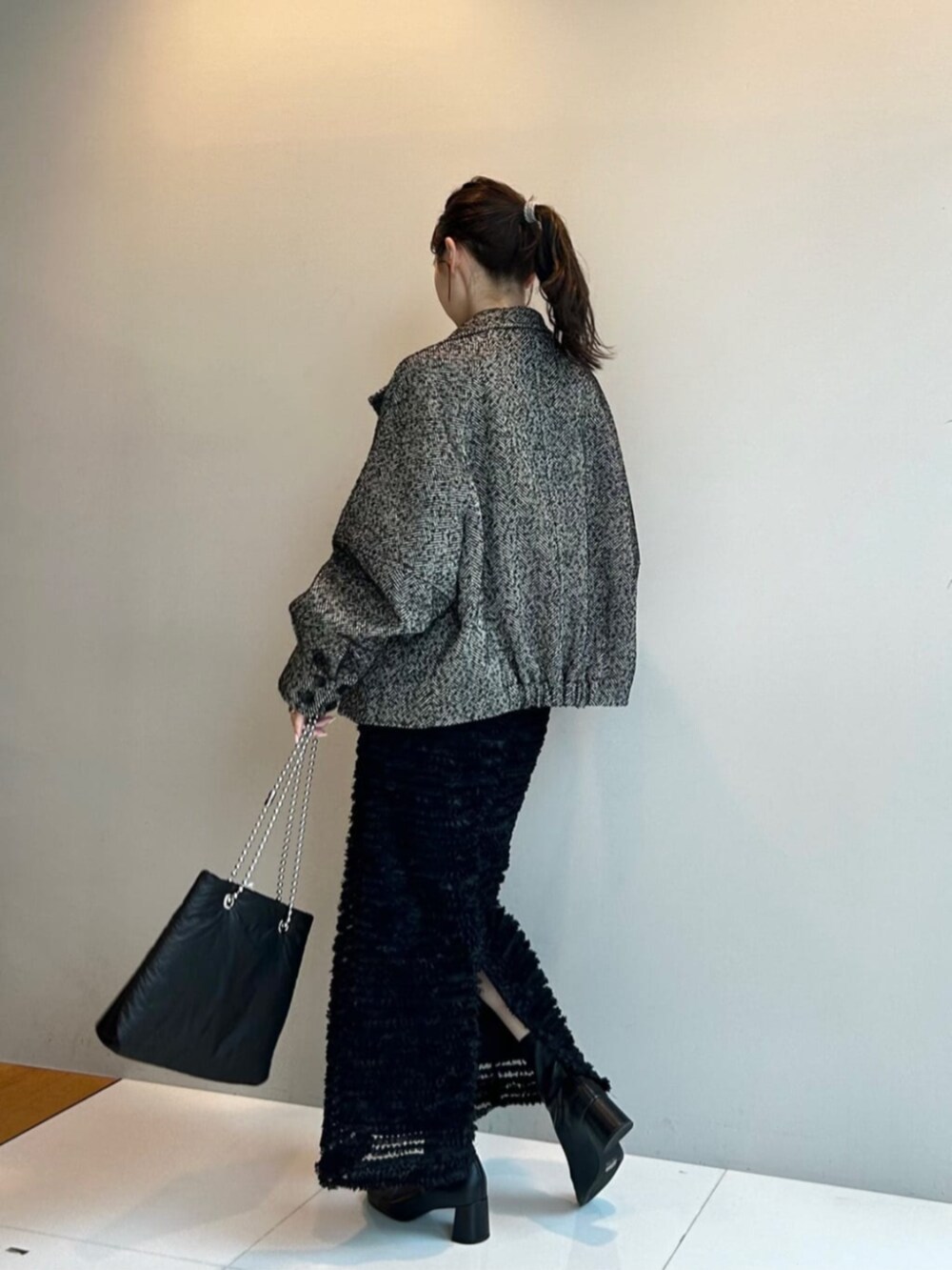 ブラック系のスカート、ブラック系のその他アウター、グレー系のTシャツ/カットソーを着用したレディースの秋コーディネートの3枚目の写真