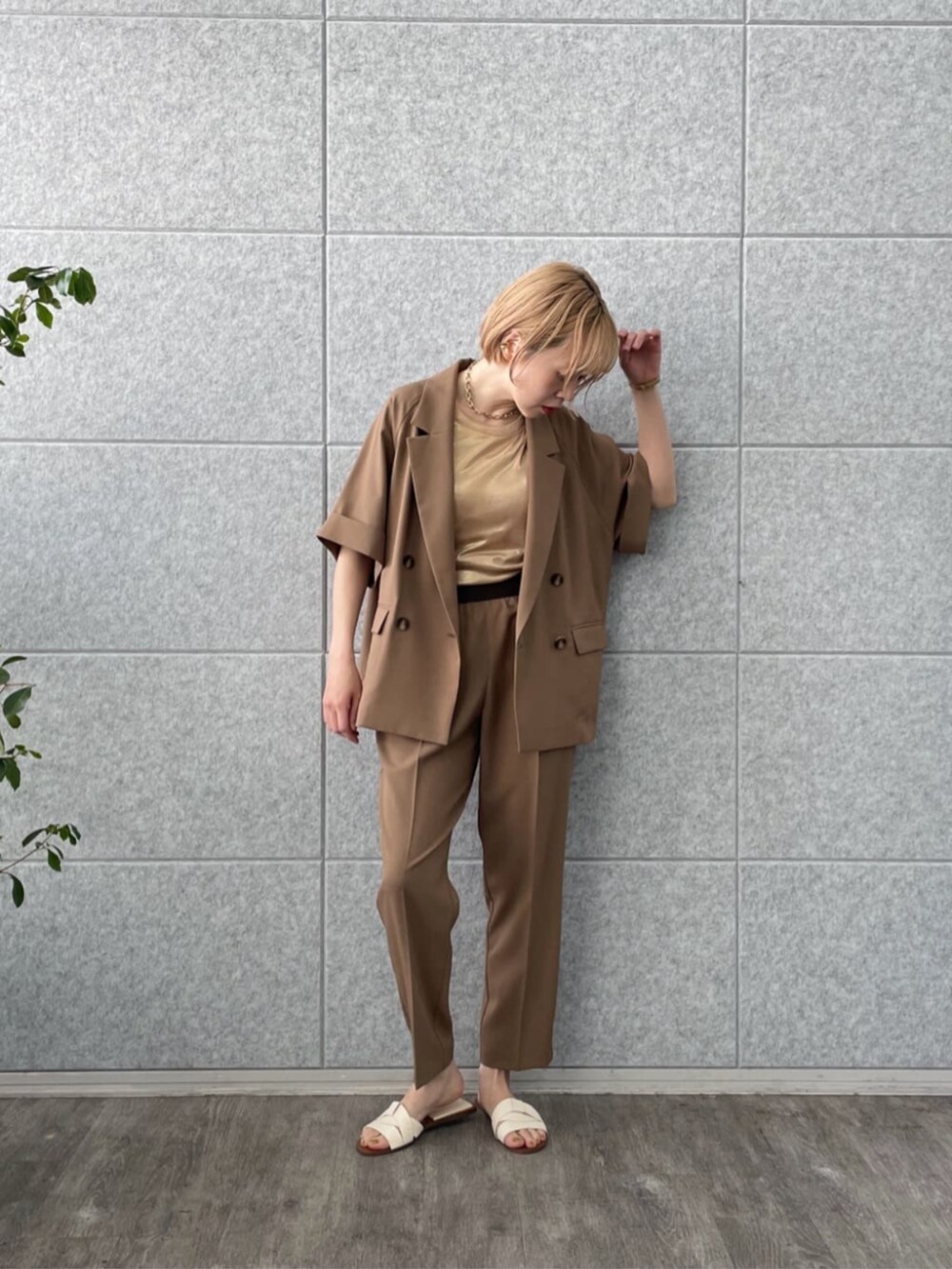 イエロー系のテーラードジャケット、ゴールド系のタンクトップ、イエロー系のその他パンツを着用したレディースの春コーディネートの4枚目の写真