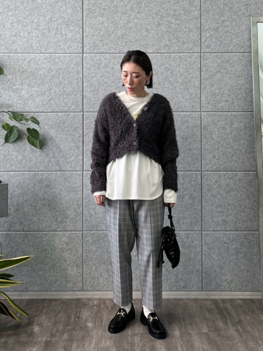 ホワイト系のTシャツ/カットソー、グレー系のカーディガン/ボレロ、グレー系のその他パンツを着用したレディースの冬コーディネートの2枚目の写真