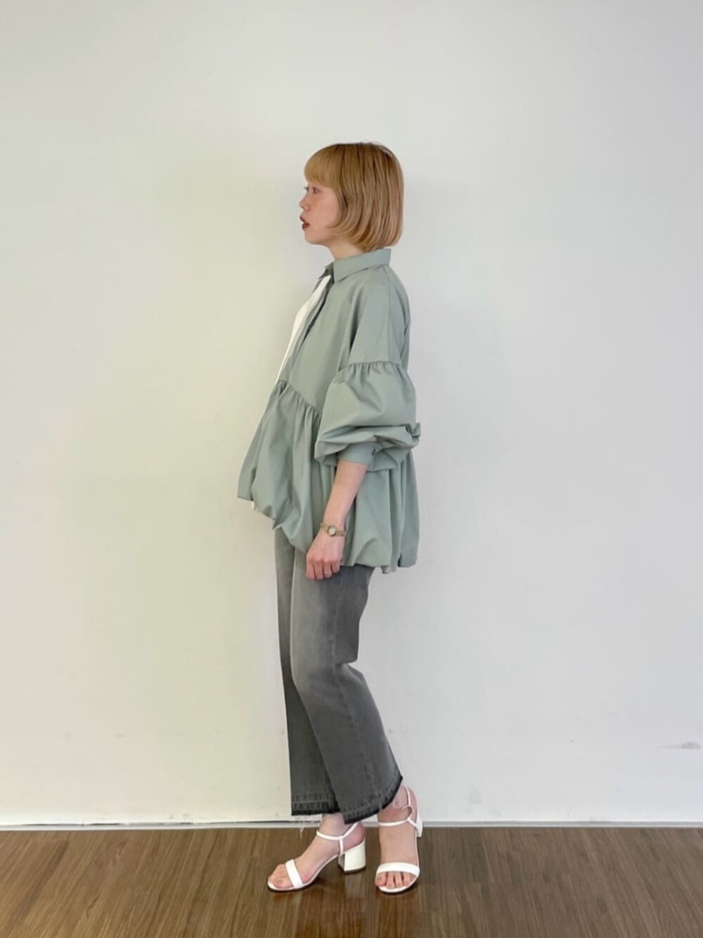 グレー系のデニムパンツ、グリーン系のシャツ/ブラウス、ホワイト系のトートバッグを着用したレディースの春コーディネートの4枚目の写真