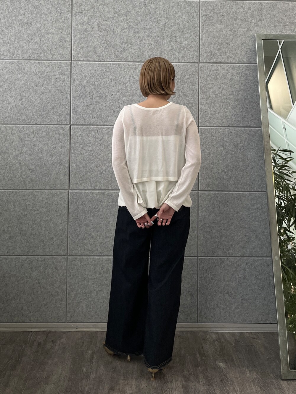 ブルー系のデニムパンツ、ホワイト系のアンサンブルを着用したレディースの春コーディネートの5枚目の写真