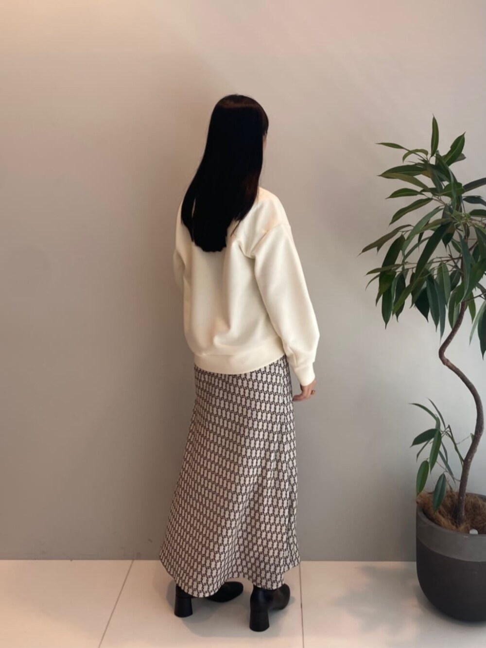 ベージュ系のスカート、ホワイト系のTシャツ/カットソーを着用したレディースの秋コーディネートの3枚目の写真