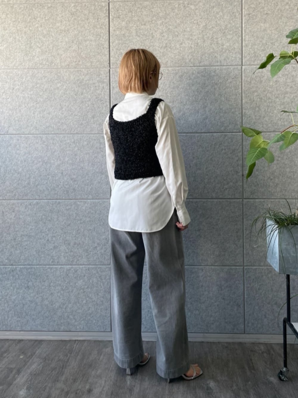 グレー系のデニムパンツ、ブラック系のベスト、ホワイト系のシャツ/ブラウスを着用したレディースの春コーディネートの3枚目の写真