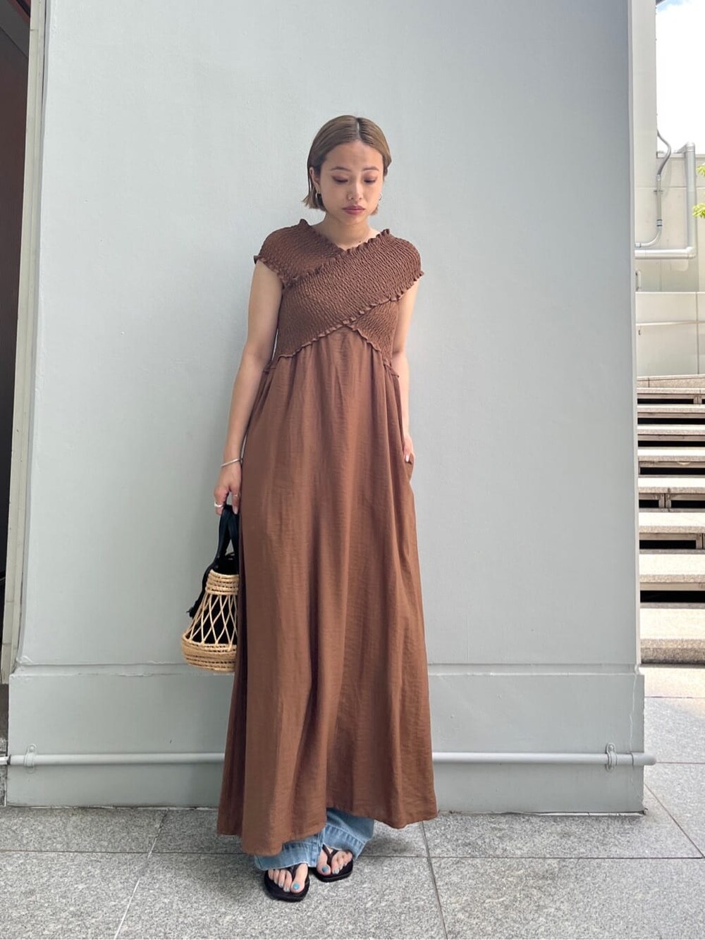 ブラウン系のワンピース、ブルー系のデニムパンツ、ブラック系のハンドバッグを着用したレディースの夏コーディネートの9枚目の写真