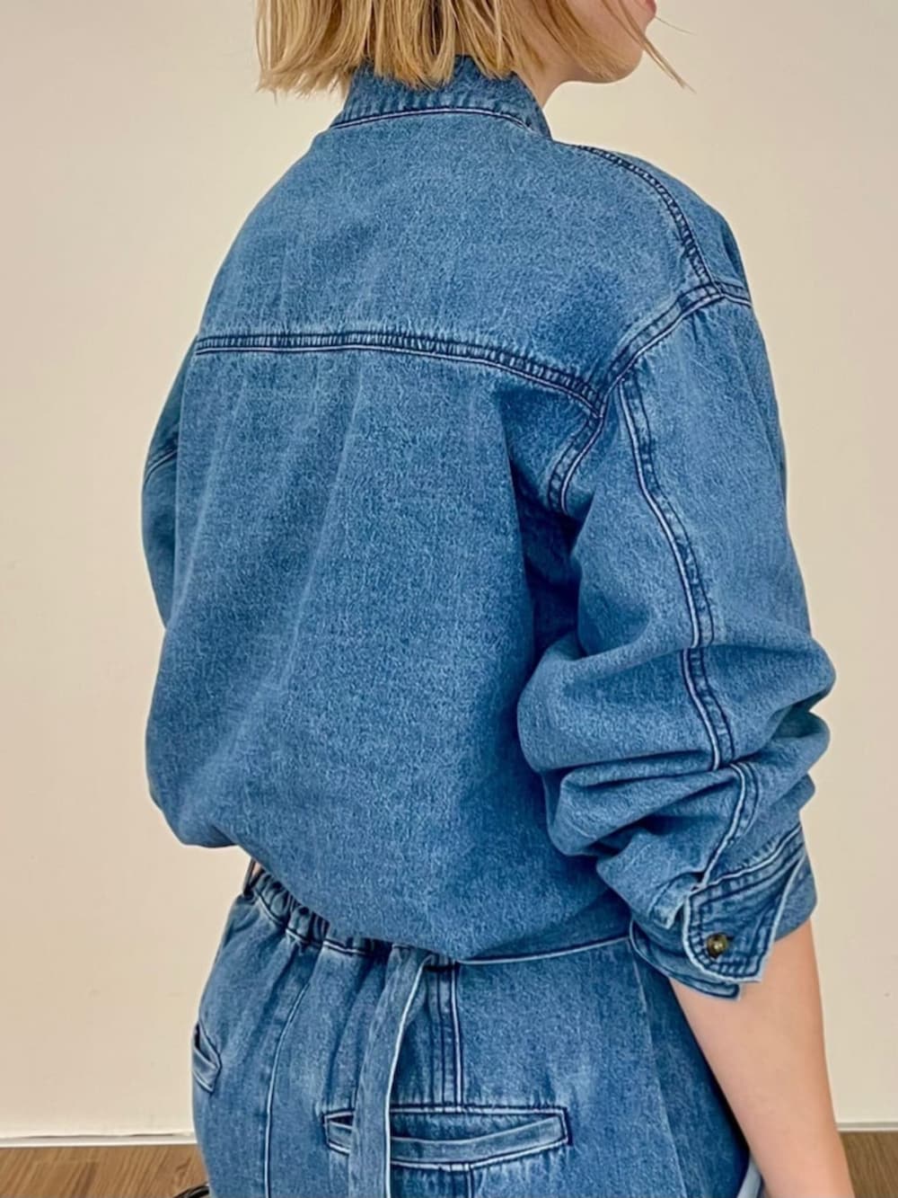 ブルー系のシャツ/ブラウス、ブルー系のデニムスカート、ブラウン系のハンドバッグを着用したレディースの秋コーディネートの4枚目の写真