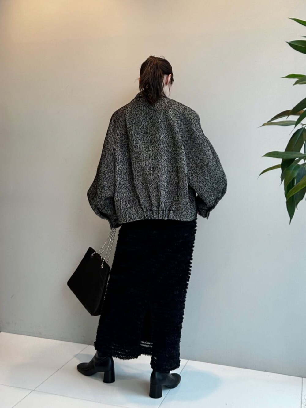 ブラック系のスカート、ブラック系のその他アウター、グレー系のTシャツ/カットソーを着用したレディースの秋コーディネートの4枚目の写真