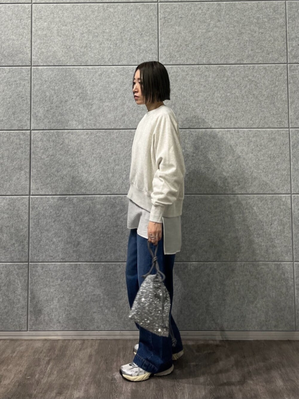 シルバー系のショルダーバッグ、ブルー系のデニムパンツ、ホワイト系のTシャツ/カットソーを着用したレディースの冬コーディネートの3枚目の写真