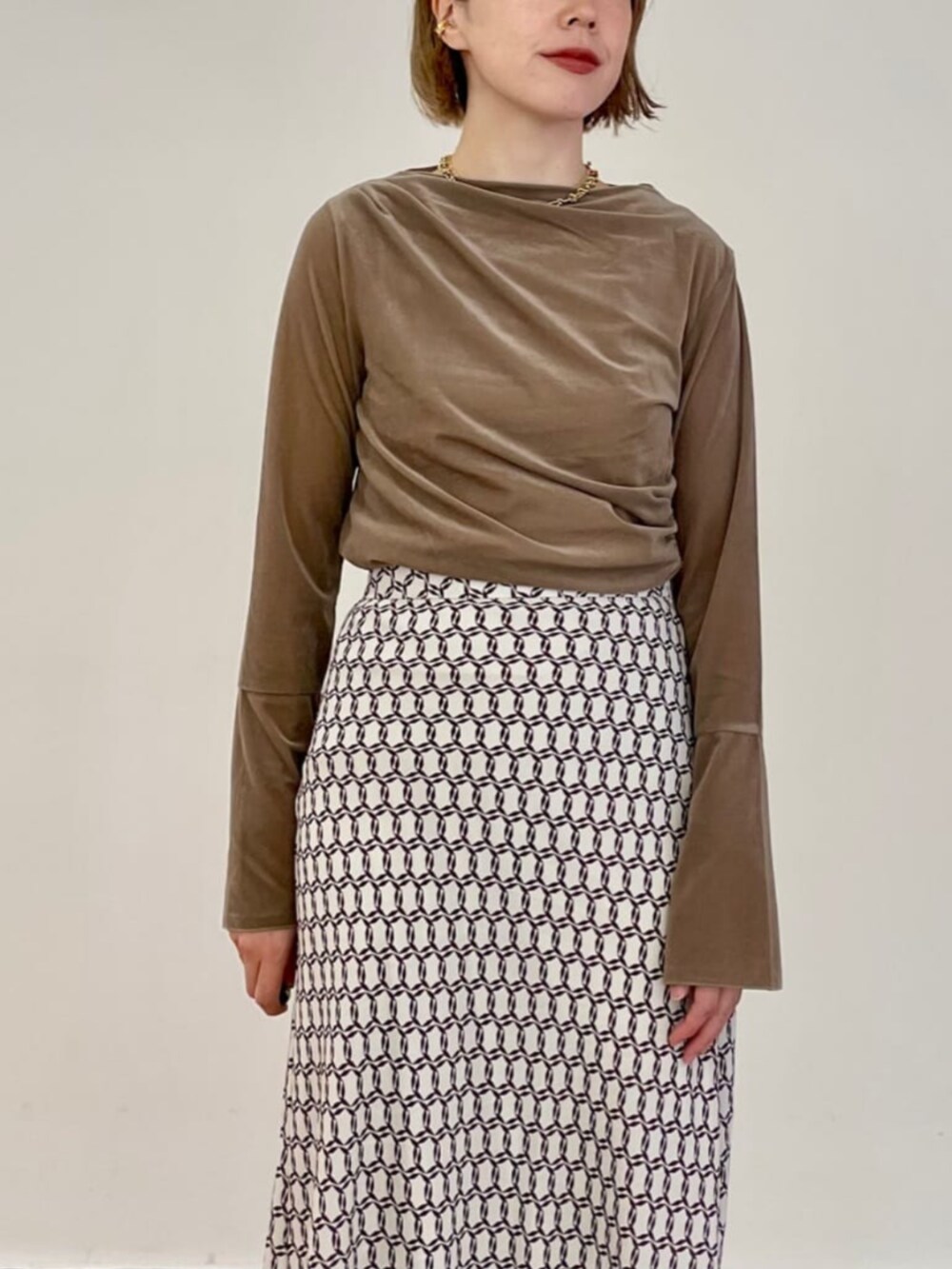 ベージュ系のスカート、ベージュ系のTシャツ/カットソーを着用したレディースの秋コーディネートの2枚目の写真